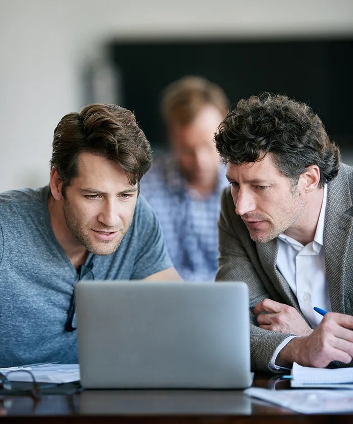 Colleagues reviewing link building work on a laptop