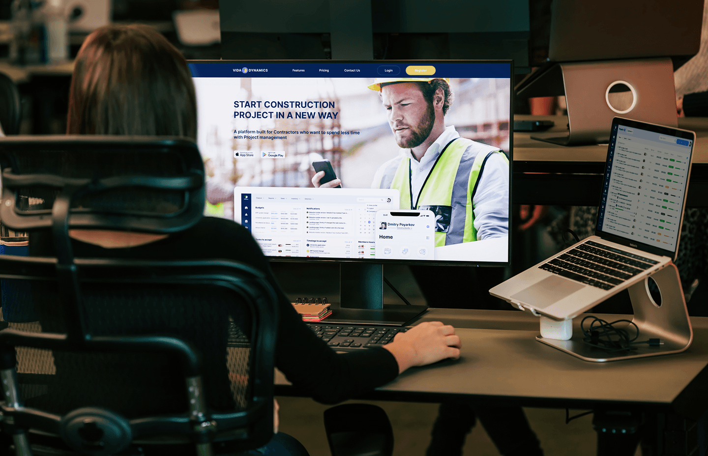 Team member reviewing Vida Dynamic dashboard on a monitor and laptop