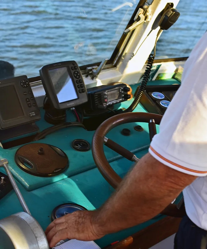Boat helm with marine electronics and a hand steering
