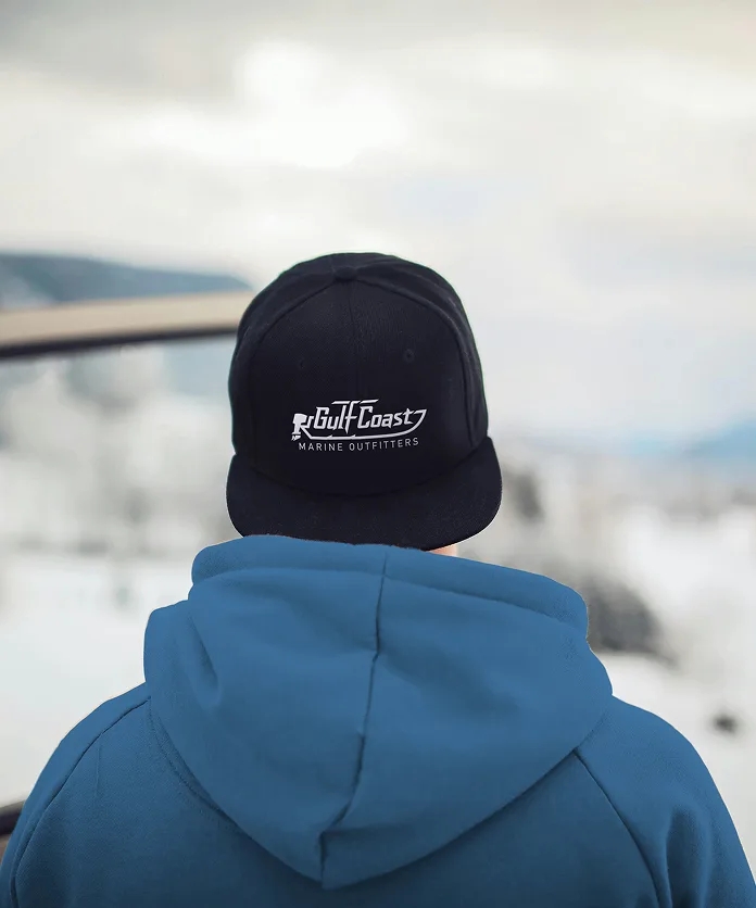 Person wearing a Gulf Coast branded cap on a boat