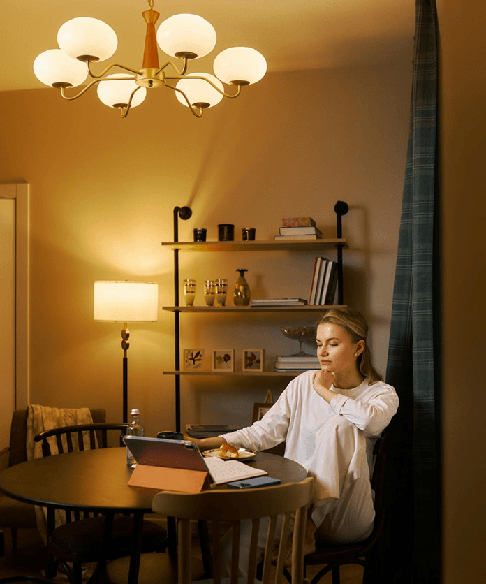 Woman working under chandelier