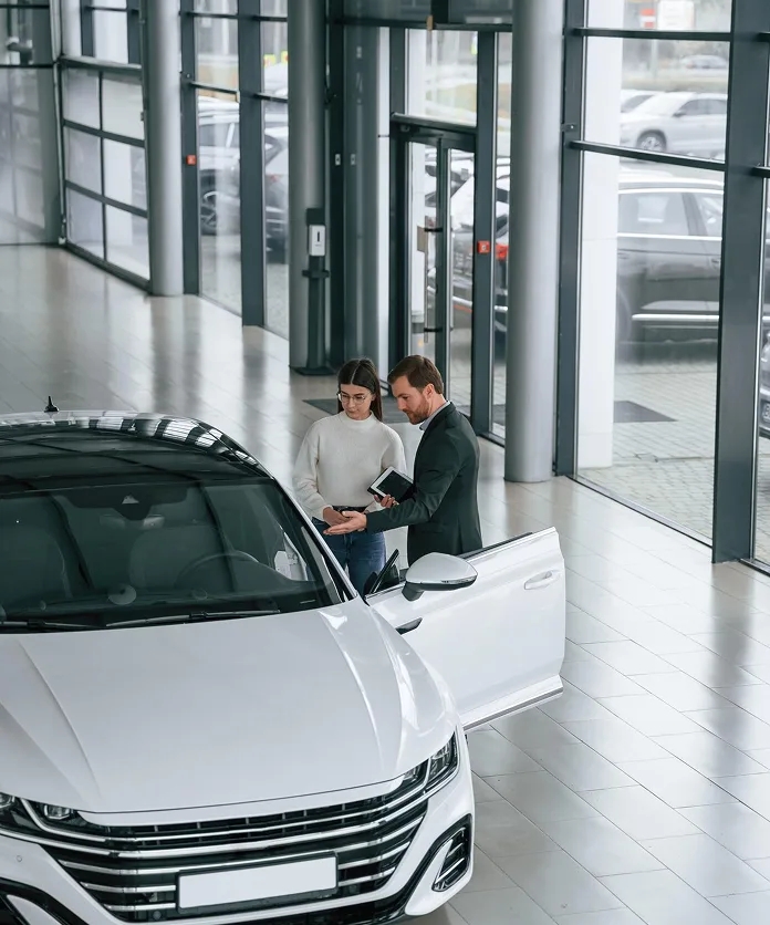 Salesperson discussing a white car with a customer