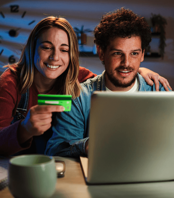 Couple checking laptop screen and holding a credit card